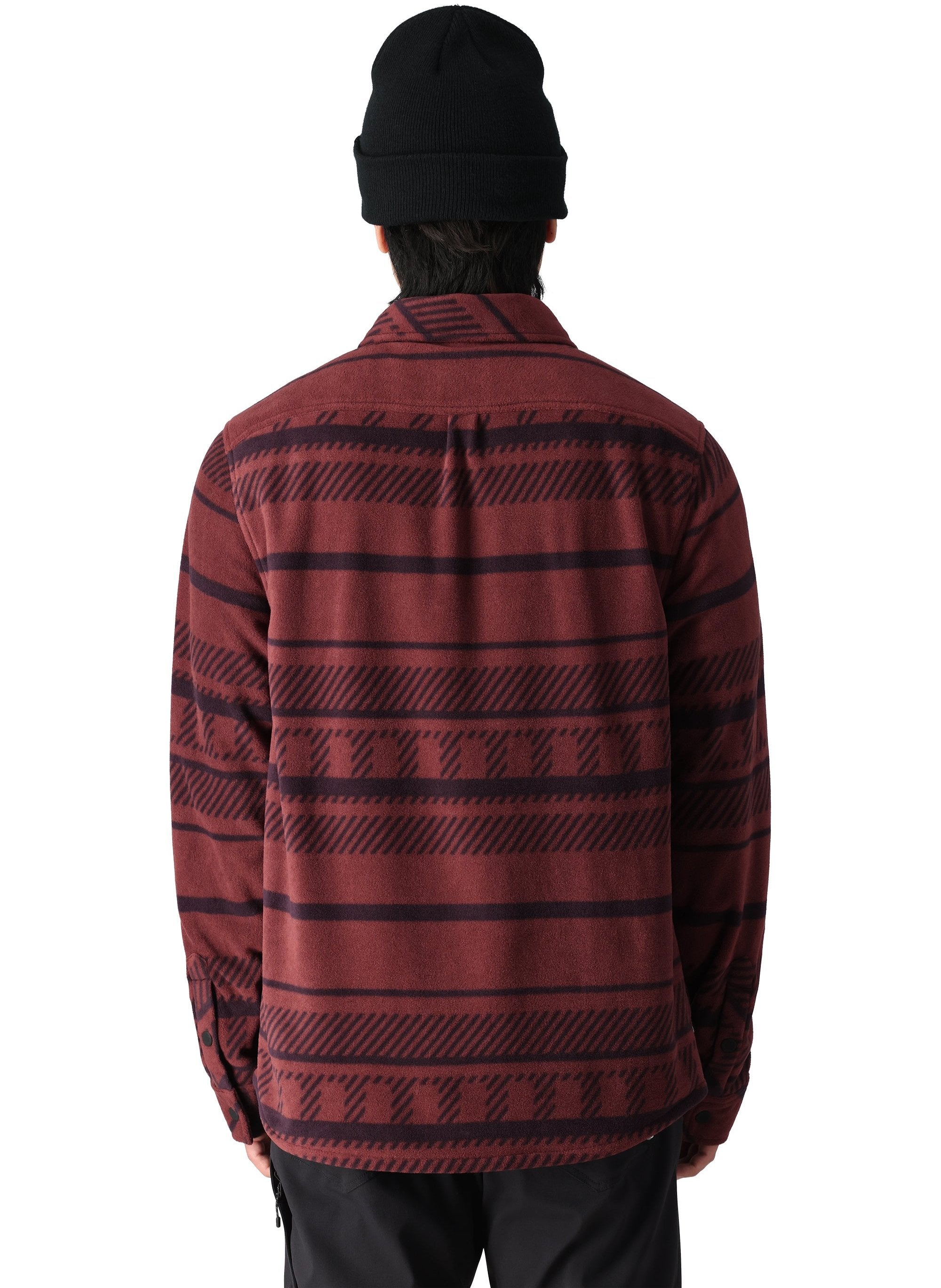 A man wearing a burgundy and black striped long-sleeved flannel shirt with a collar and button-down front stands facing away from the camera.