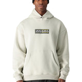 A man wearing a cream-colored 686 hoodie with two pockets and an elastic waistband.
