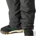 The 686 Men's Quantum Thermagraph Pant 2025 is dark gray with zippered pockets and a black drawstring on the waist.