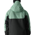The 686 Renewal Insulated Anorak Jacket in this front view features a black body with mint-green shoulders and hood.