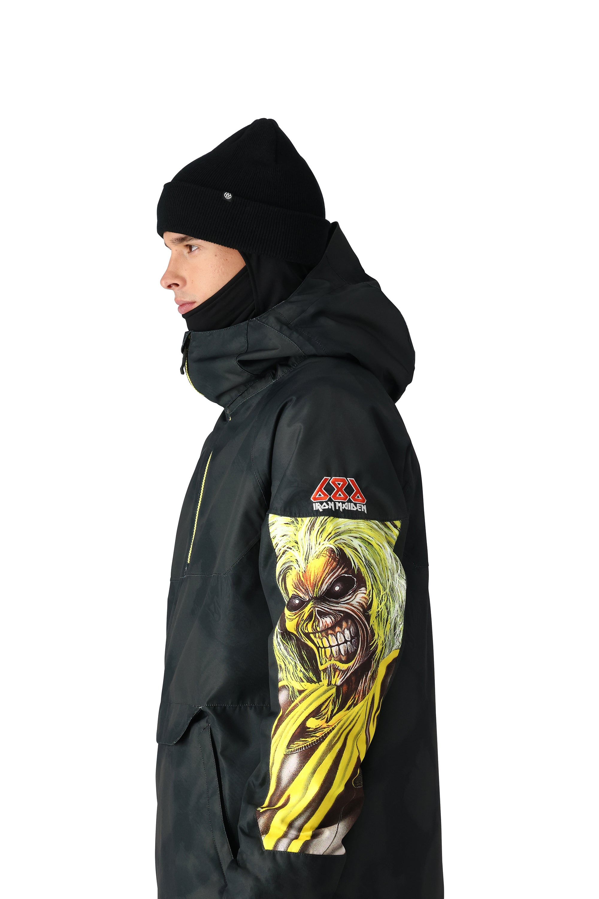 The 686 Renewal Insulated Anorak Jacket 2025 has a black color and showcases an Iron Maiden graphic on the front.