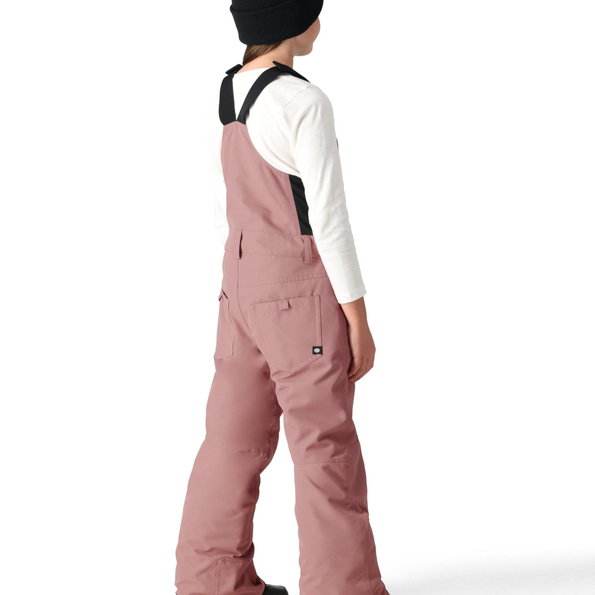 The 686 Girl's Sierra Insulated Bib features a dusty rose color and front zip closure with additional side snap buttons.