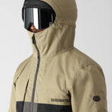 The 686 Smarty 3-in-1 Form Jacket is primarily tan with black accents and has an insulated hood.