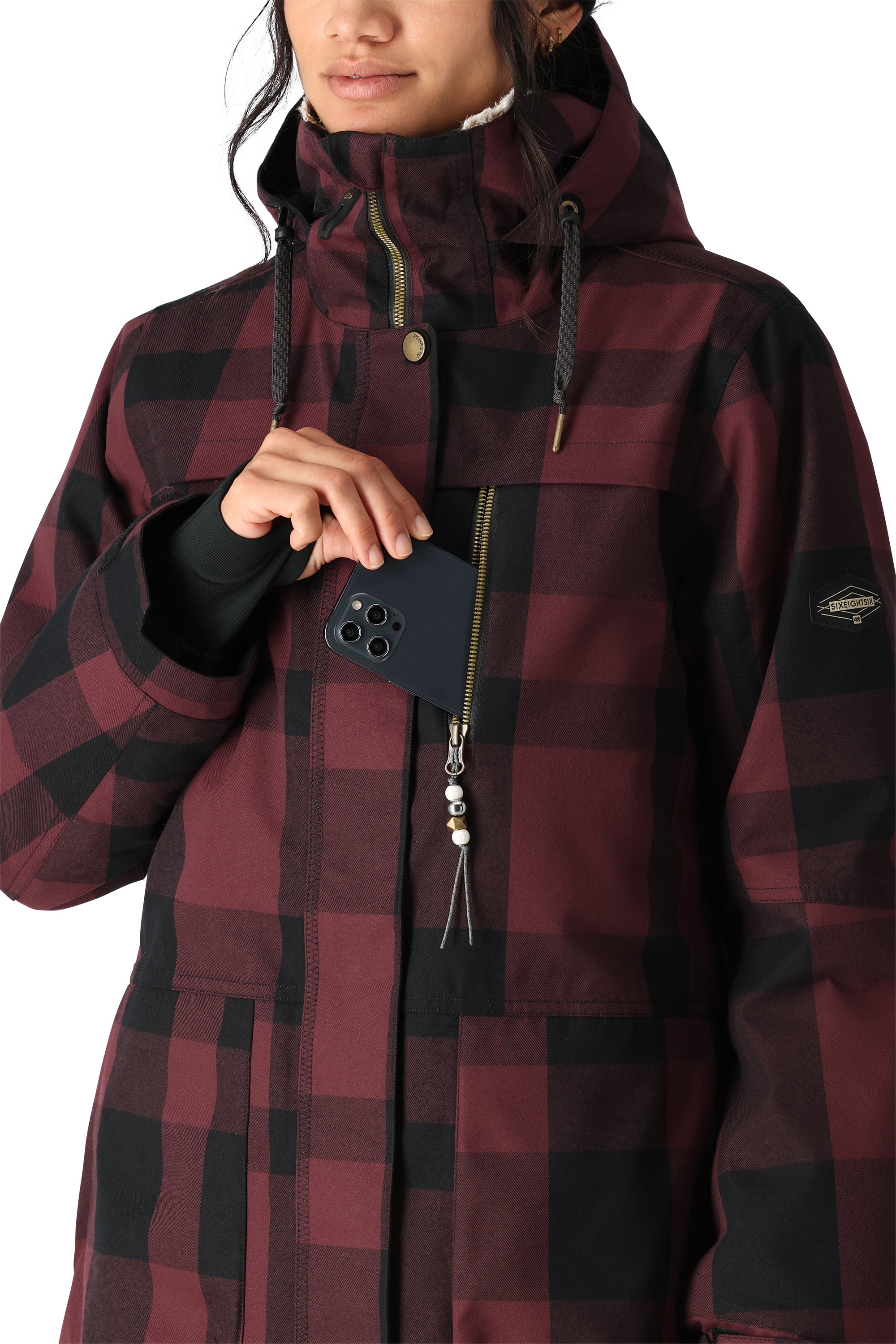 The 686 Spirit Insulated Jacket in burgundy and black plaid has an insulated hood with drawstrings.