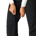 The 686 Women's Standard Shell Pant 2025 is black with a zippered thigh pocket and adjustable velcro waist tab.