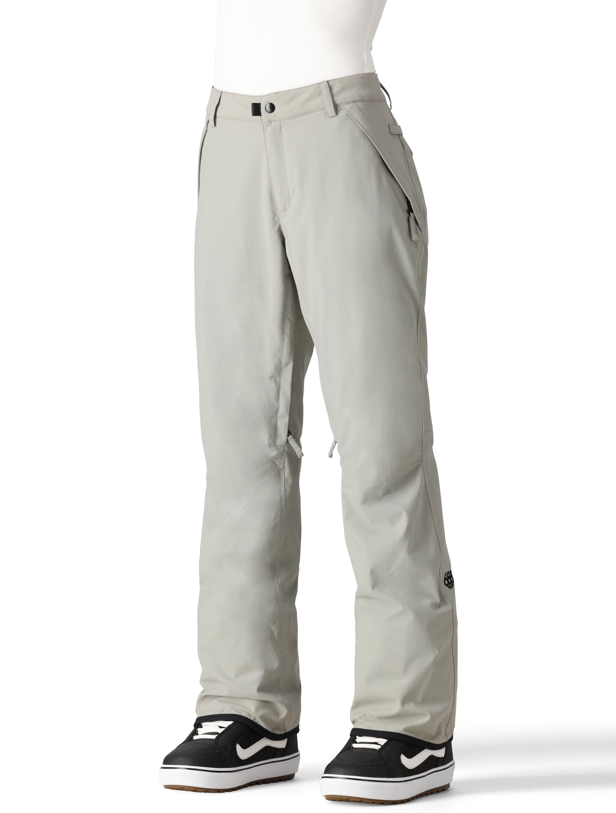 The 686 Women's Standard Shell Pant 2025 is primarily white with black accents and has zippered pockets along the sides.