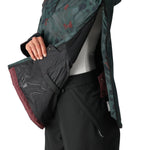 The 686 Women's Upton Insulated Anorak Jacket 2025 is predominantly black with a green and red camouflage pattern on the hood and upper back.