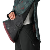 The 686 Women's Upton Insulated Anorak Jacket 2025 is predominantly black with a green and red camouflage pattern on the hood and upper back.