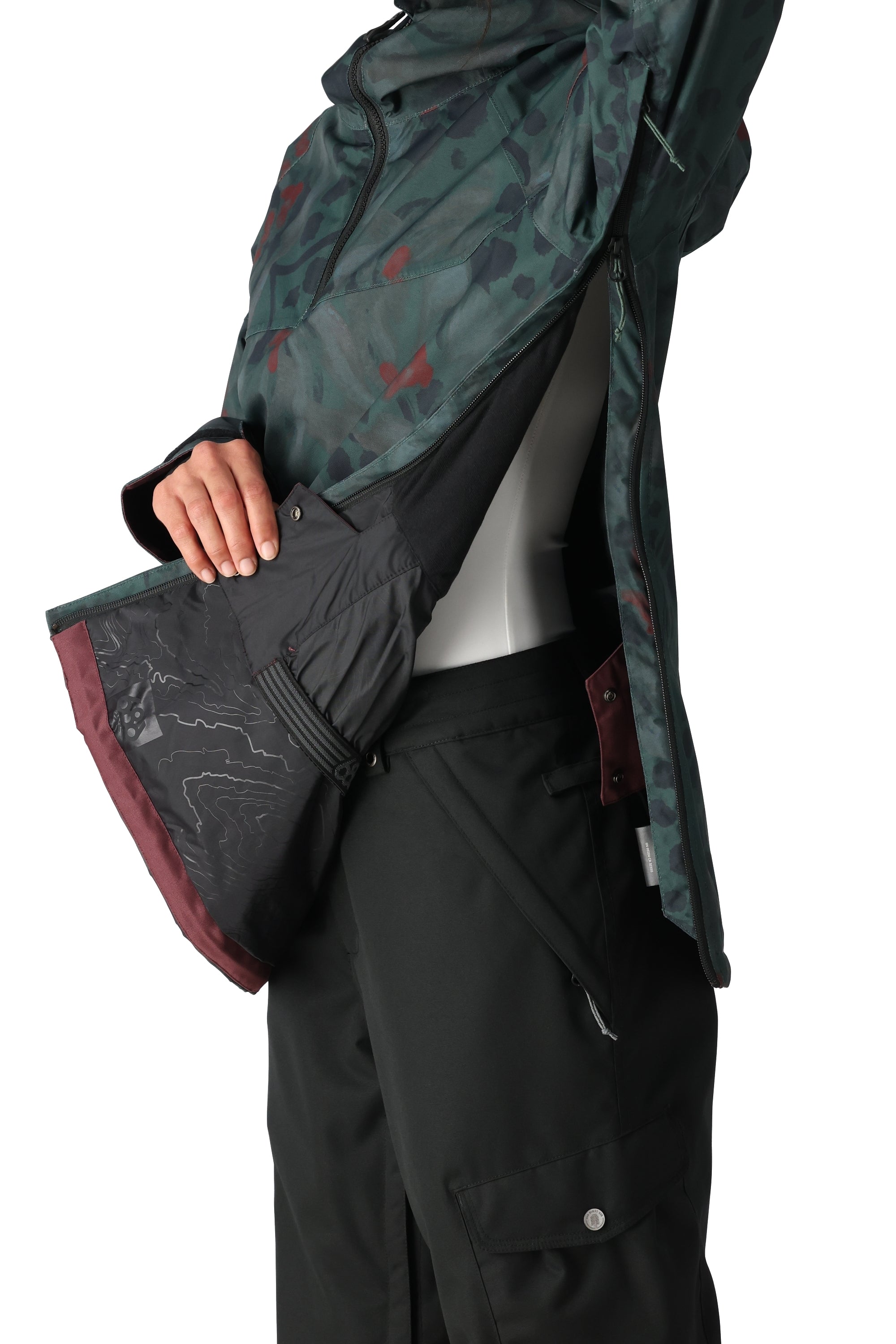 The 686 Women's Upton Insulated Anorak Jacket 2025 is predominantly black with a green and red camouflage pattern on the hood and upper back.