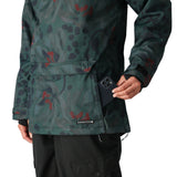 The 686 brand women's Upton insulated anorak jacket has a green floral pattern with red flowers and black leaves on a dark background.