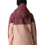 The 686 Women's Upton Insulated Anorak Jacket 2025 is primarily a muted pink jacket with a burgundy hood and black trim.