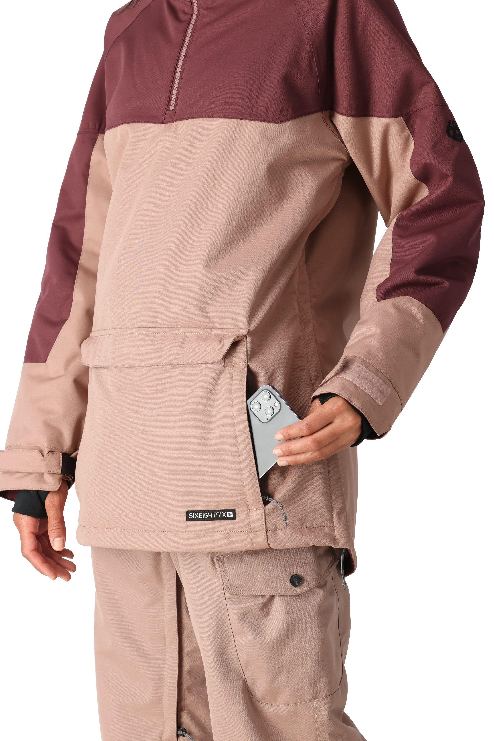 The 686 Women's Upton Insulated Anorak Jacket in tan and maroon has a front zipper and an insulated hood.