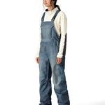 The 686 Women's Black Magic 20K Shell Bib, as seen from the front view, is a blue bib pant with a high waist and adjustable straps.