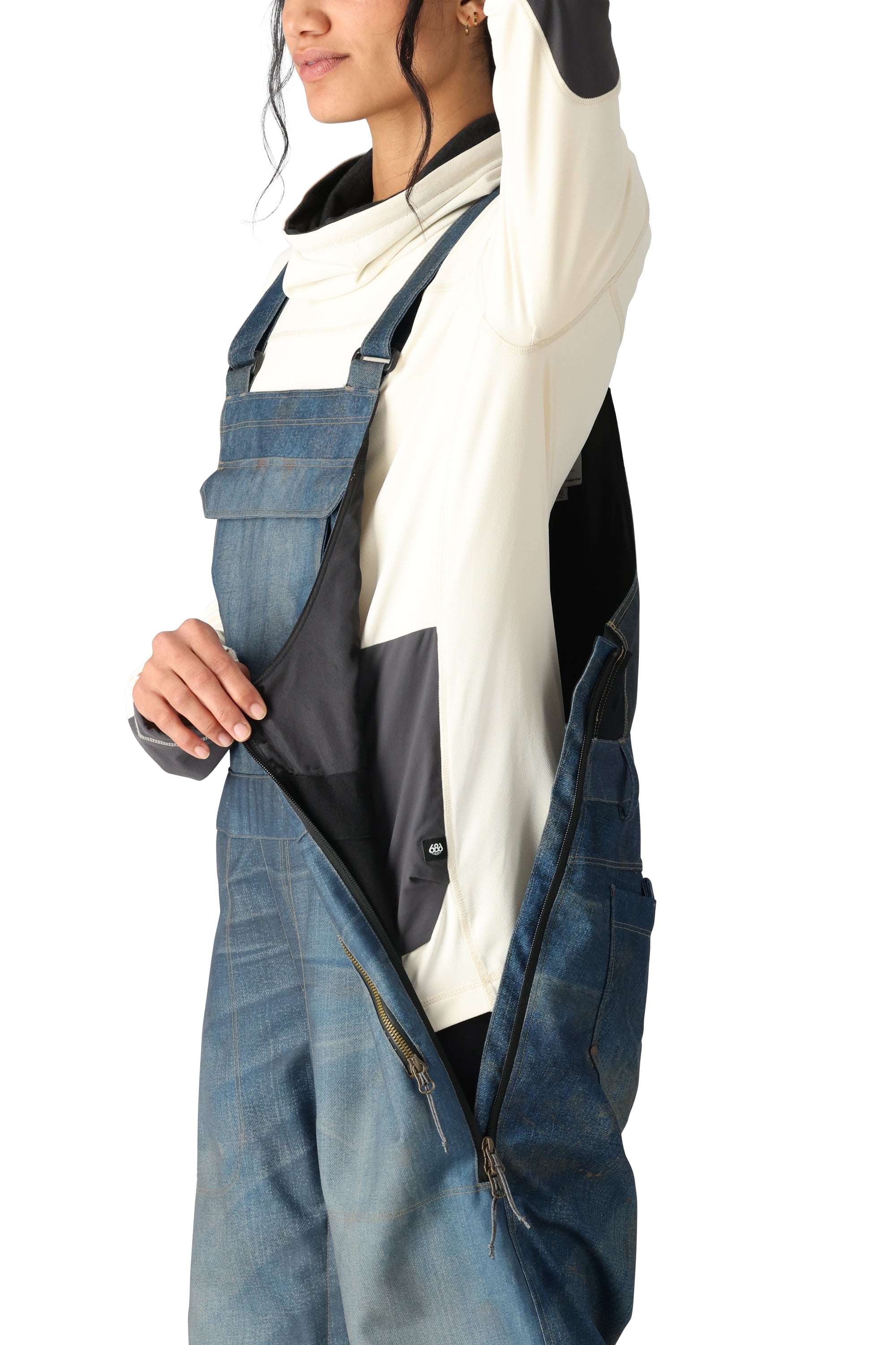 The 686 Black Magic 20K shell bib has a dark blue color and a distinctive black stripe running down the side.