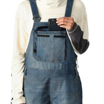 The 686 Women's Black Magic 20K Shell Bib features a light-colored shell with black trim and adjustable straps.