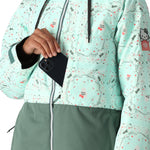 The 686 Women's Athena Insulated Jacket 2025 is primarily light teal with a darker green bottom half and has an insulated hood.
