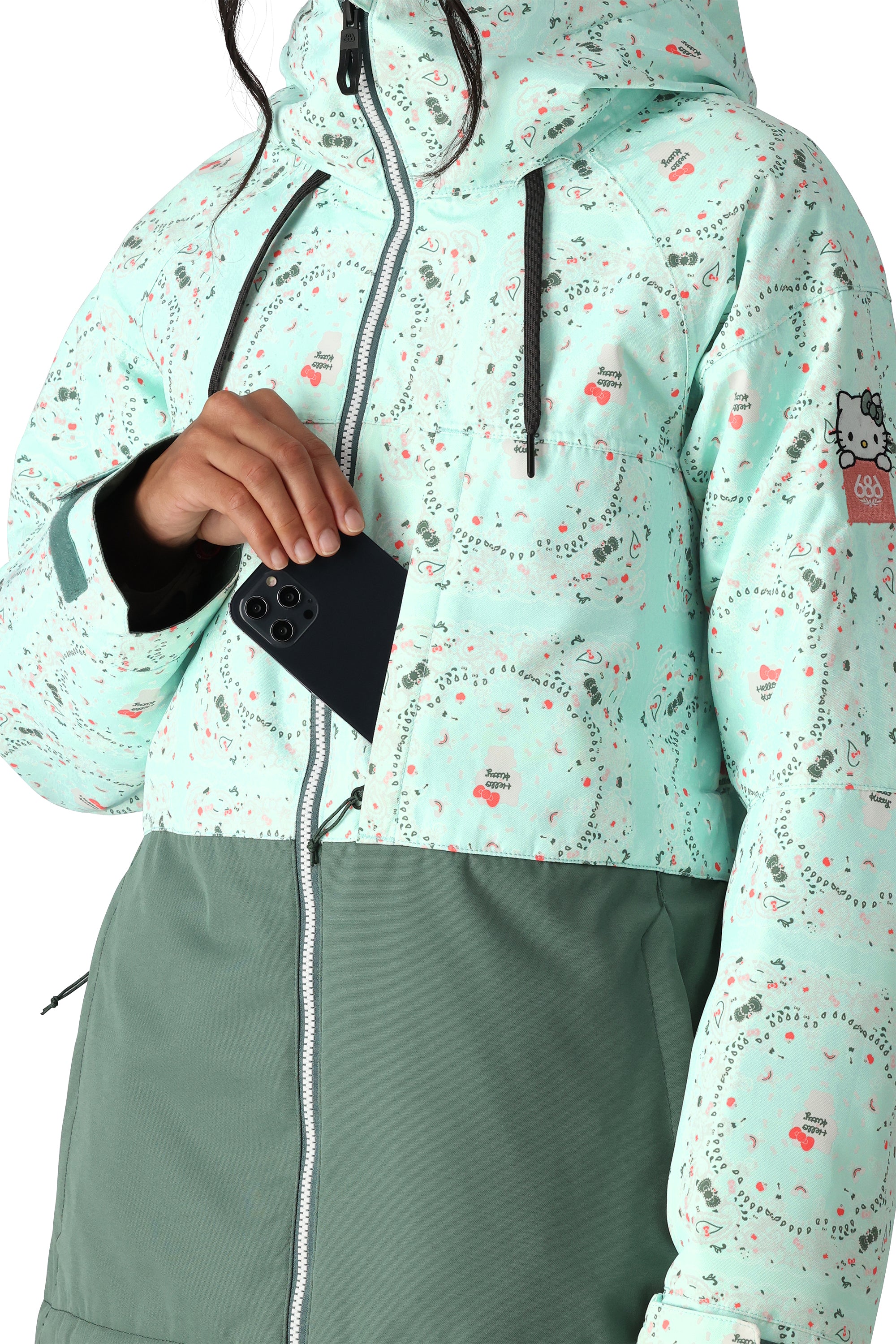 The 686 Women's Athena Insulated Jacket 2025 is primarily light teal with a darker green bottom half and has an insulated hood.