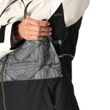 The 686 Women's Athena Insulated Jacket 2025 is primarily black and white with an abstract geometric pattern on the torso area.