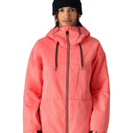 The 686 Women's Athena Insulated Jacket 2025 is showcased in this front view image, wearing a vibrant coral color with black drawstrings and a prominent hood.