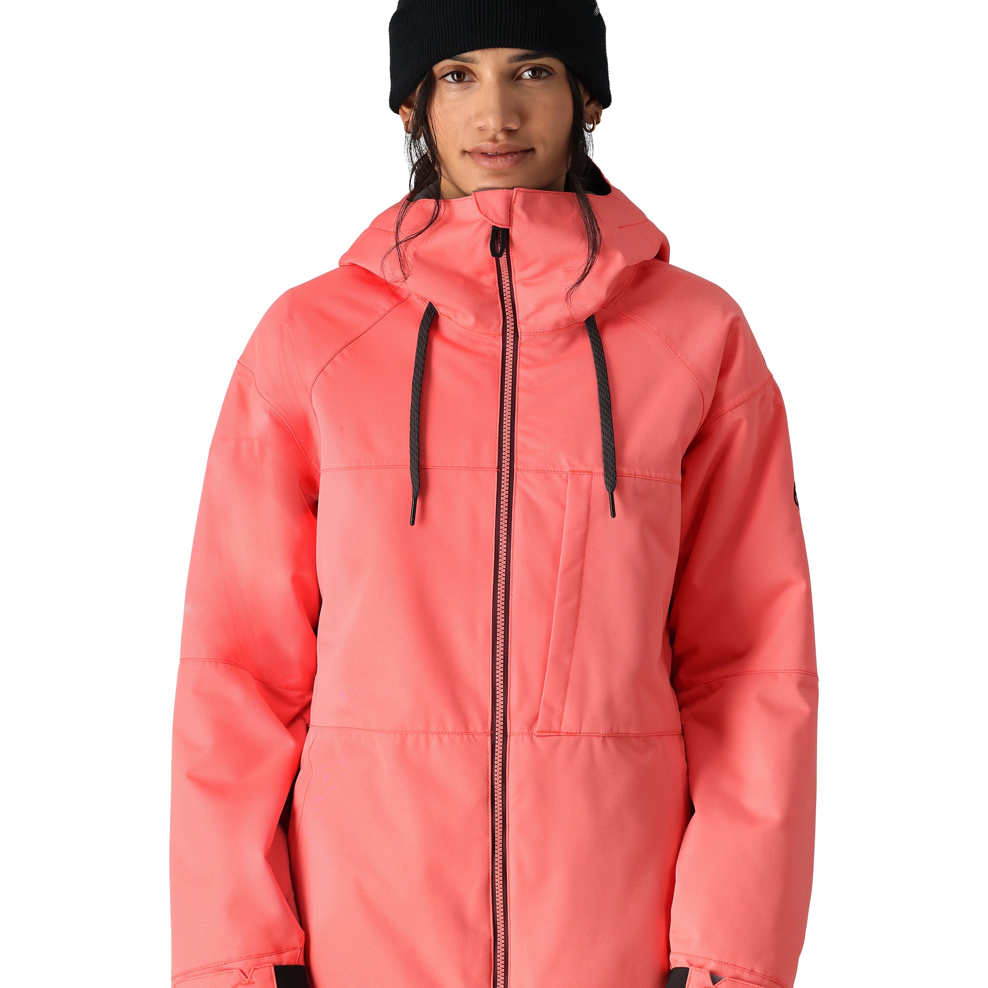 The 686 Women's Athena Insulated Jacket 2025 is showcased in this front view image, wearing a vibrant coral color with black drawstrings and a prominent hood.