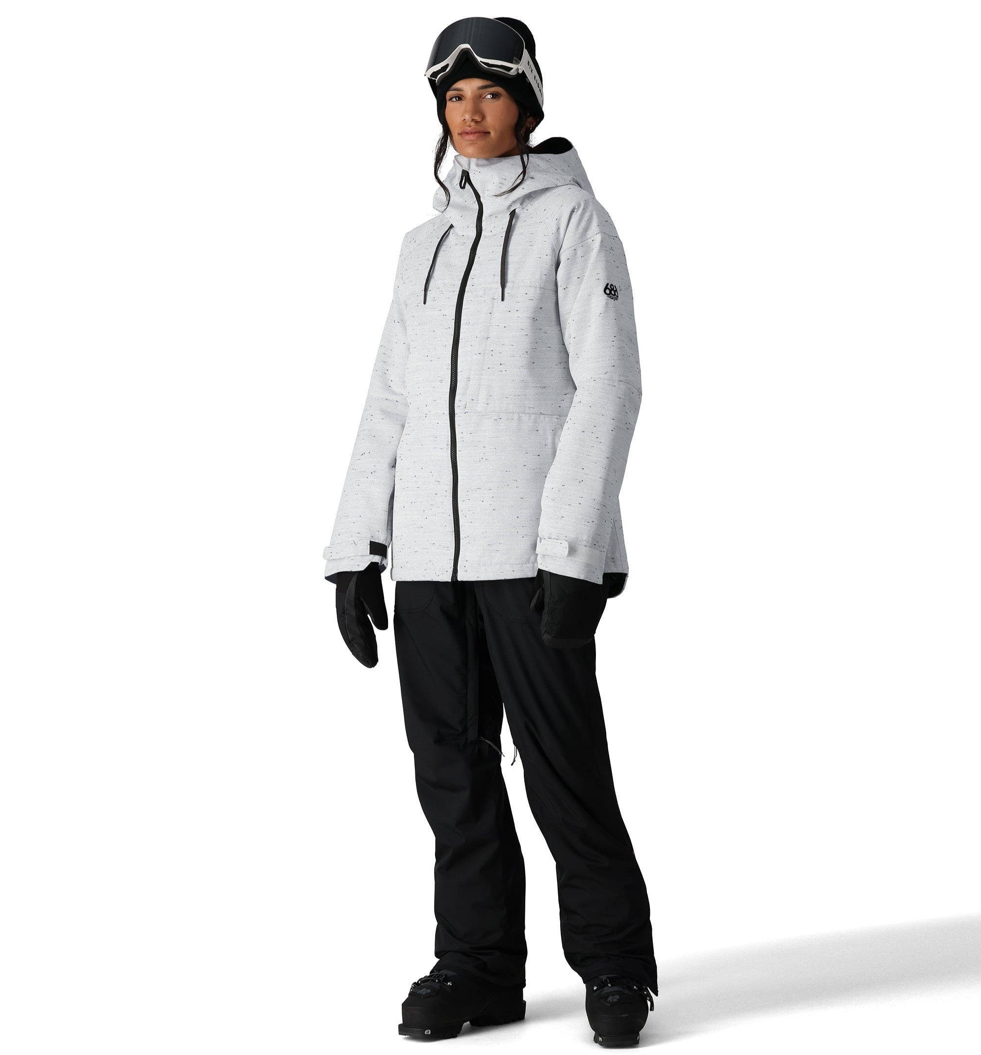 The 686 Women's Athena Insulated Jacket 2025 is predominantly white with black speckles and features a zippered front, drawstring hood, and thumbholes in black.