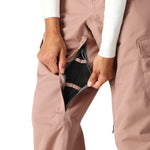The 686 Women's Aura Insulated Cargo Pant 2025 is shown from the front view in dusty rose, featuring black mesh lining and a zippered fly.
