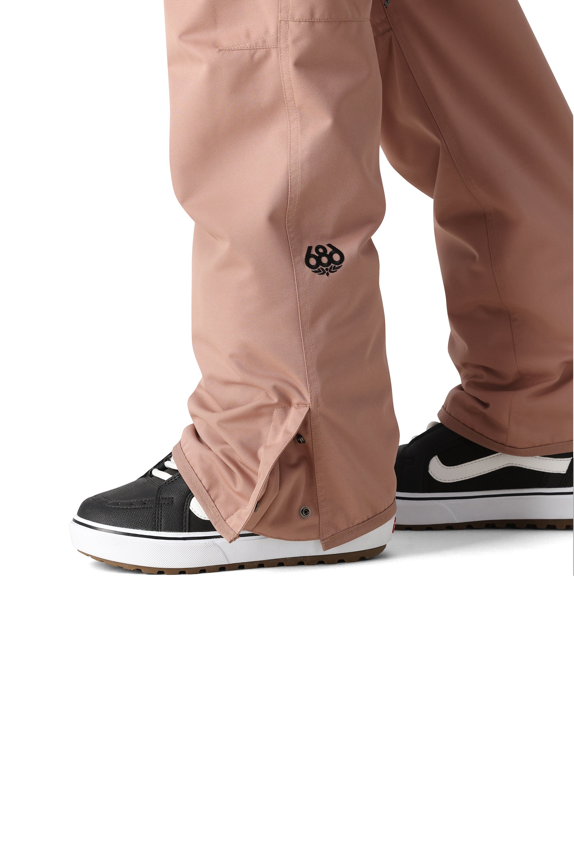 The 686 Women's Aura Insulated Cargo Pant 2025 is primarily pink with black accents and a zipper down the front.
