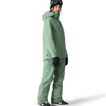 The 686 brand's Aura insulated cargo pant in sage green has two cargo pockets on either side with snap closures.