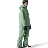 The 686 brand's Aura insulated cargo pant in sage green has two cargo pockets on either side with snap closures.