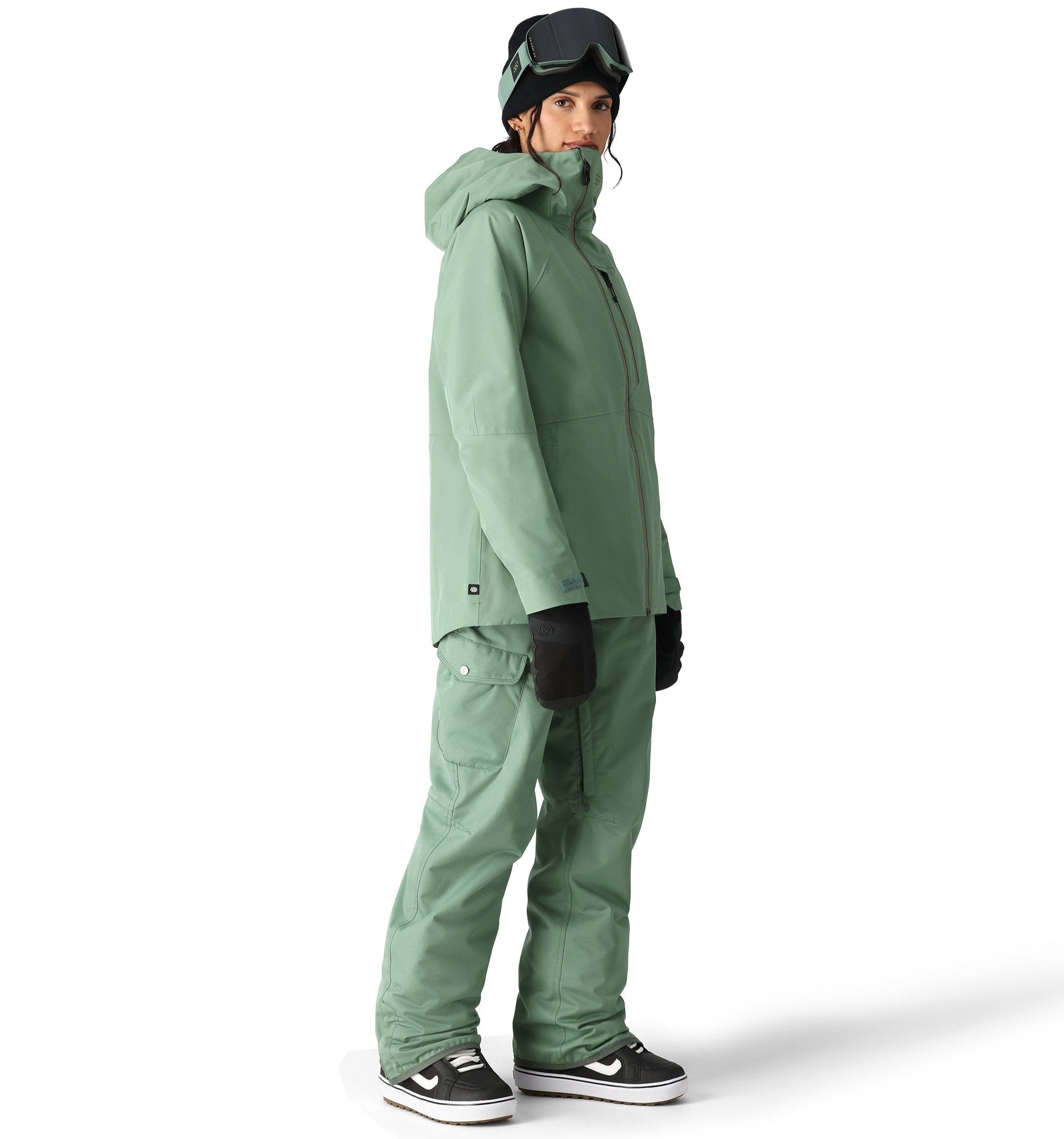 The 686 brand's Aura insulated cargo pant in sage green has two cargo pockets on either side with snap closures.