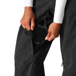 The 686 Women's Aura Insulated Cargo Pant 2025 in dark grey has two front zippered pockets and an adjustable waistband.