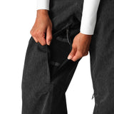 The 686 Women's Aura Insulated Cargo Pant 2025 in dark grey has two front zippered pockets and an adjustable waistband.