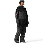 The 686 Aura Insulated Cargo Pant features a black and dark gray color scheme with a cargo pocket on one leg.