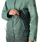 The 686 Women's Fantasia Insulated Jacket 2025 is showcased in this image from the front, featuring a dark teal color with a geometric pattern on the lower half and a black zipper.