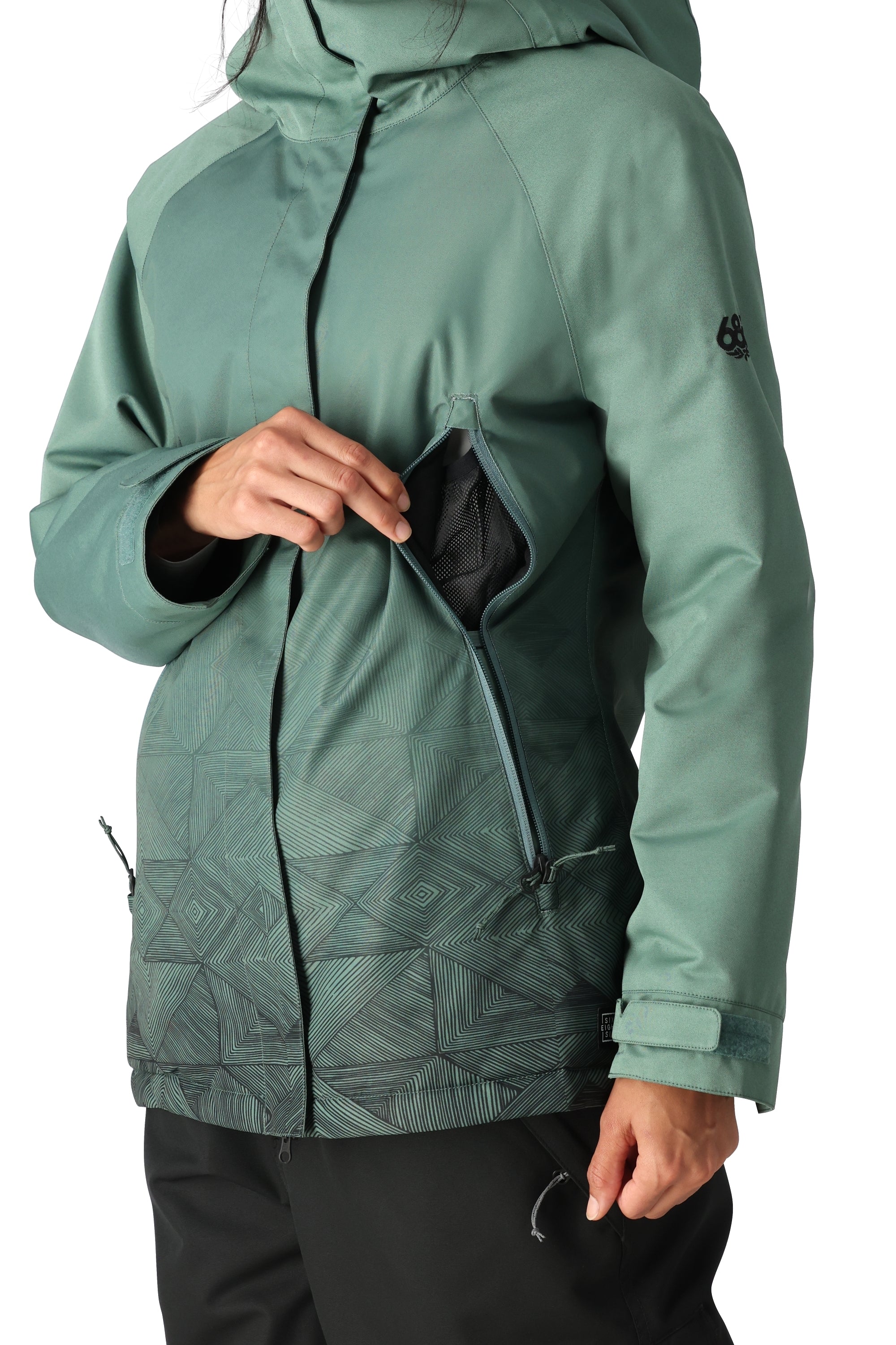 The 686 Women's Fantasia Insulated Jacket 2025 is showcased in this image from the front, featuring a dark teal color with a geometric pattern on the lower half and a black zipper.