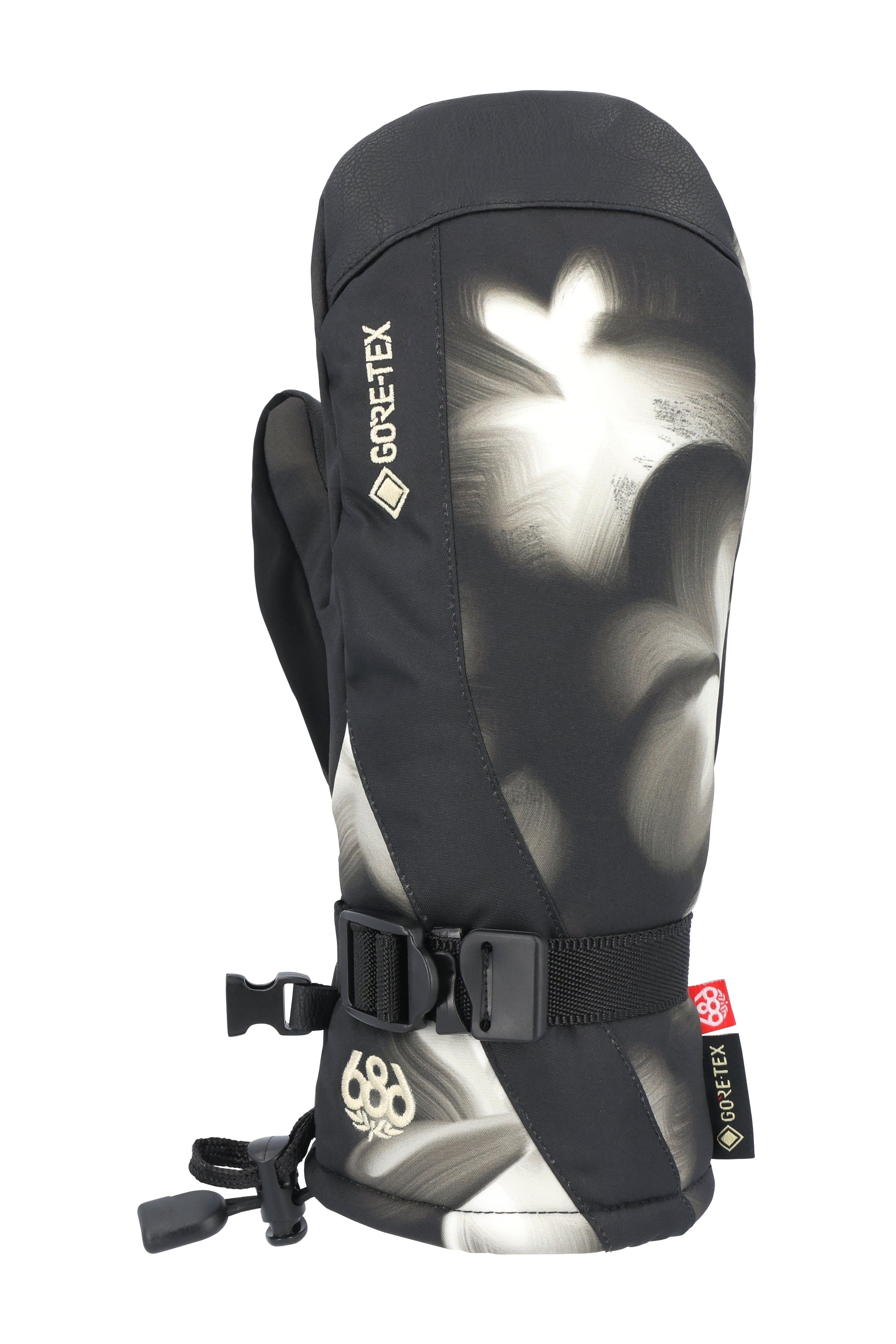 The 686 Women's GORE-TEX Linear Mitt 2025 has a black palm side with a white floral design on the back and fingers.