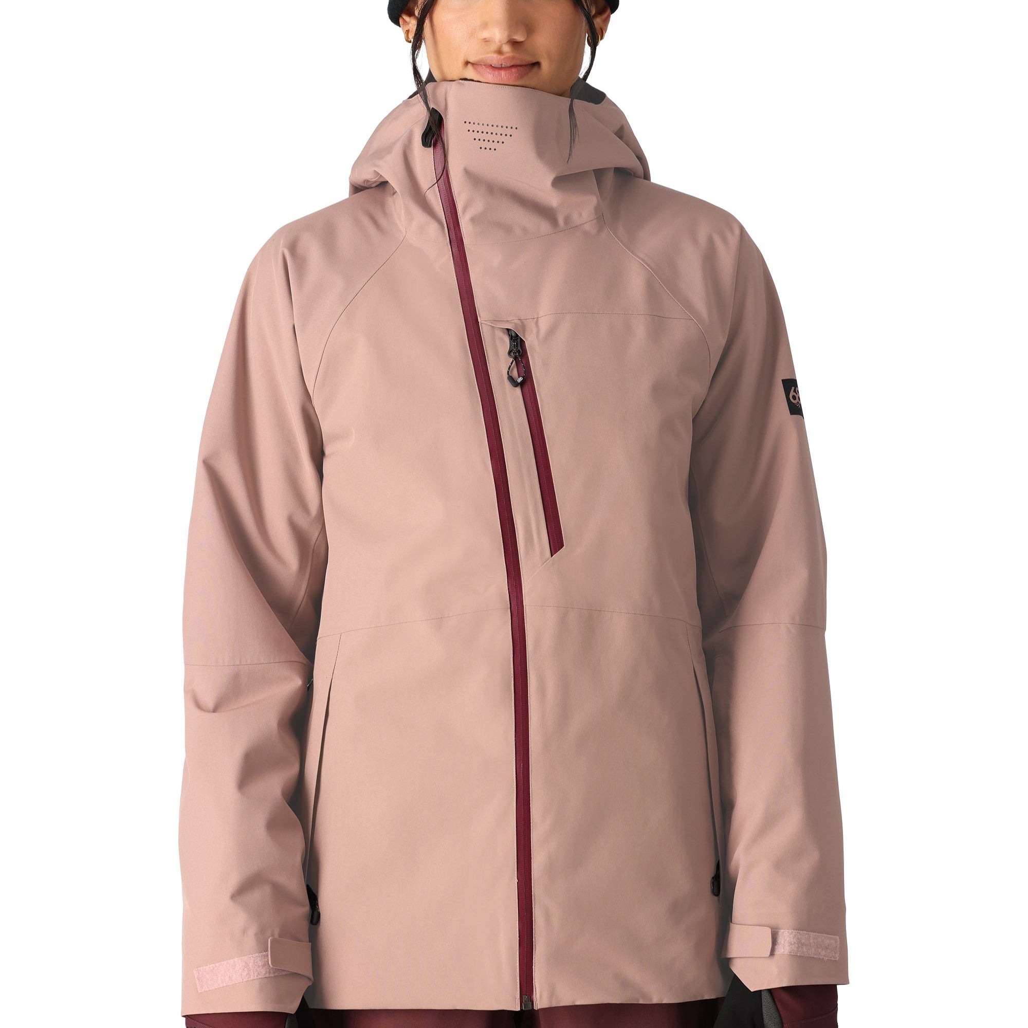 The 686 Woman's Hydra Insulated Jacket 2025 in this front view has a light pink color with maroon accents and zippers.