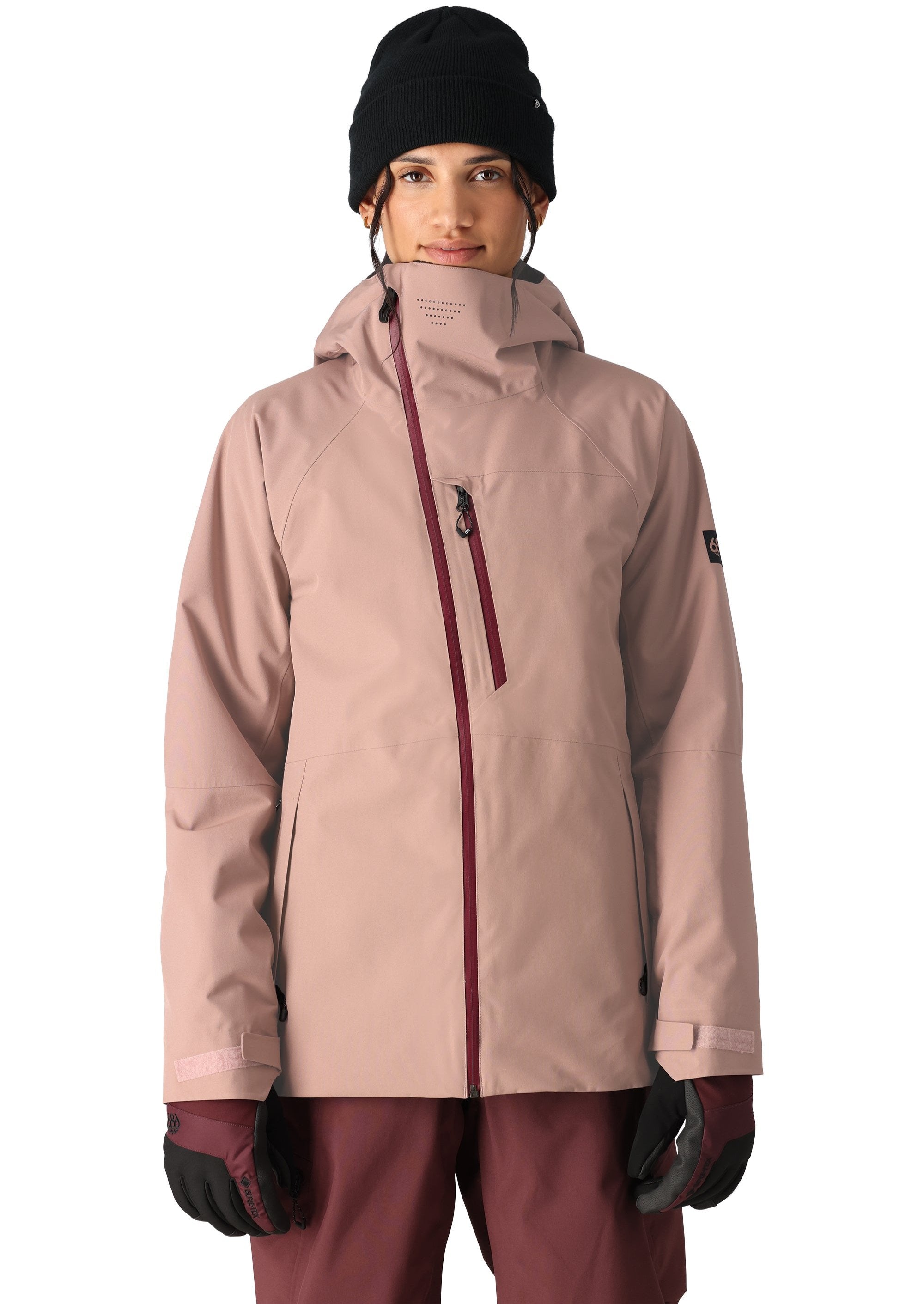 The 686 Woman's Hydra Insulated Jacket 2025 in this front view has a light pink color with maroon accents and zippers.