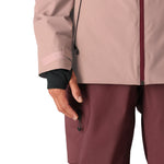The 686 Woman's Hydra Insulated Jacket 2025 is primarily light pink with a black zipper and appears to have an insulated hood.
