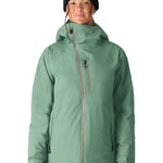 The woman's 686 Hydra Insulated Jacket, in mint green color, is shown in a front view with its hood up and a black beanie on top.