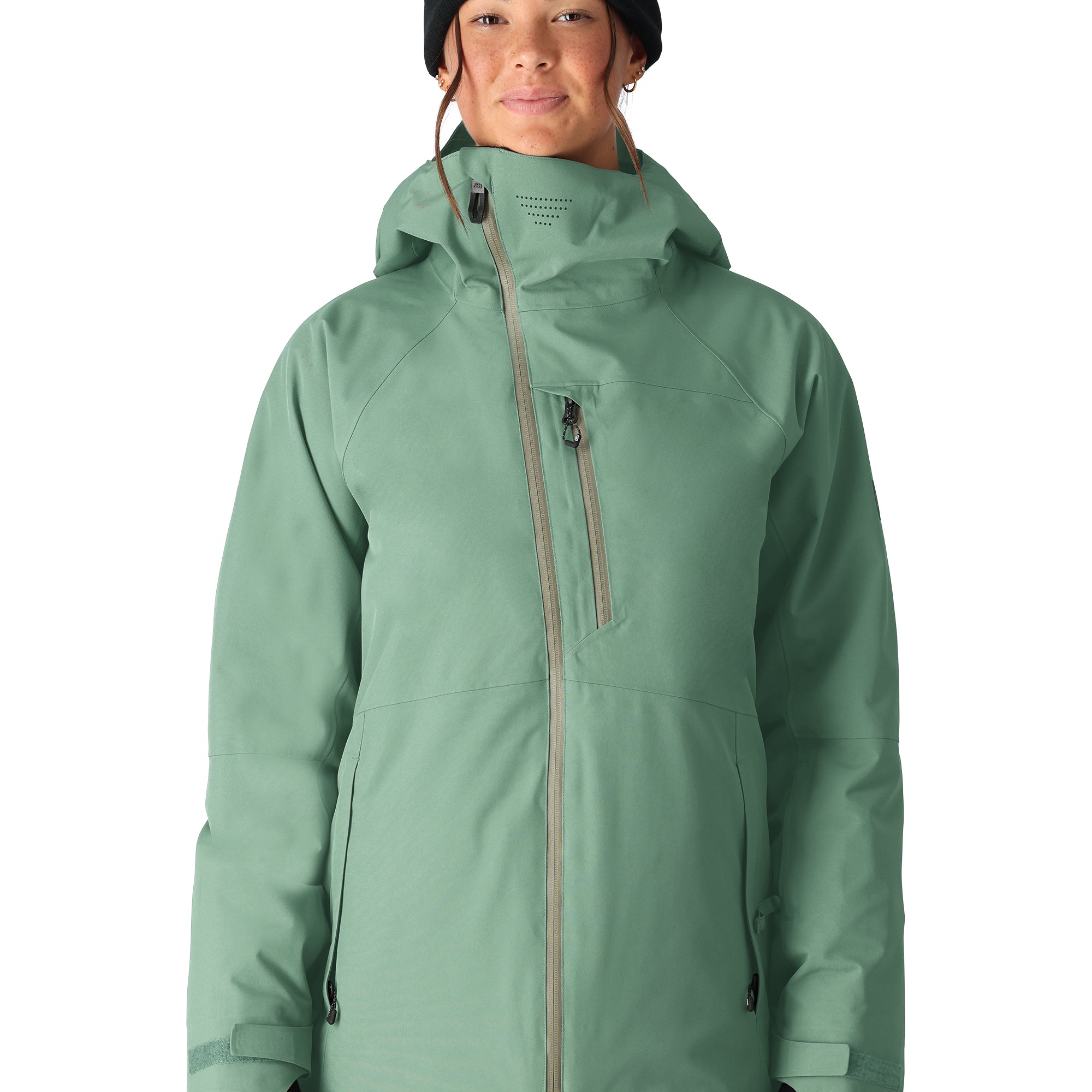 The woman's 686 Hydra Insulated Jacket, in mint green color, is shown in a front view with its hood up and a black beanie on top.
