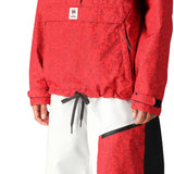 The 686 Women's Outline Shell Anorak 2025 is primarily red with a black pattern and has an adjustable drawcord at the waist.