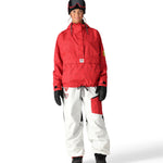 The 686 women's Outline Shell Anorak has a red and black patterned shell with a high collar and zippered pockets on either side.
