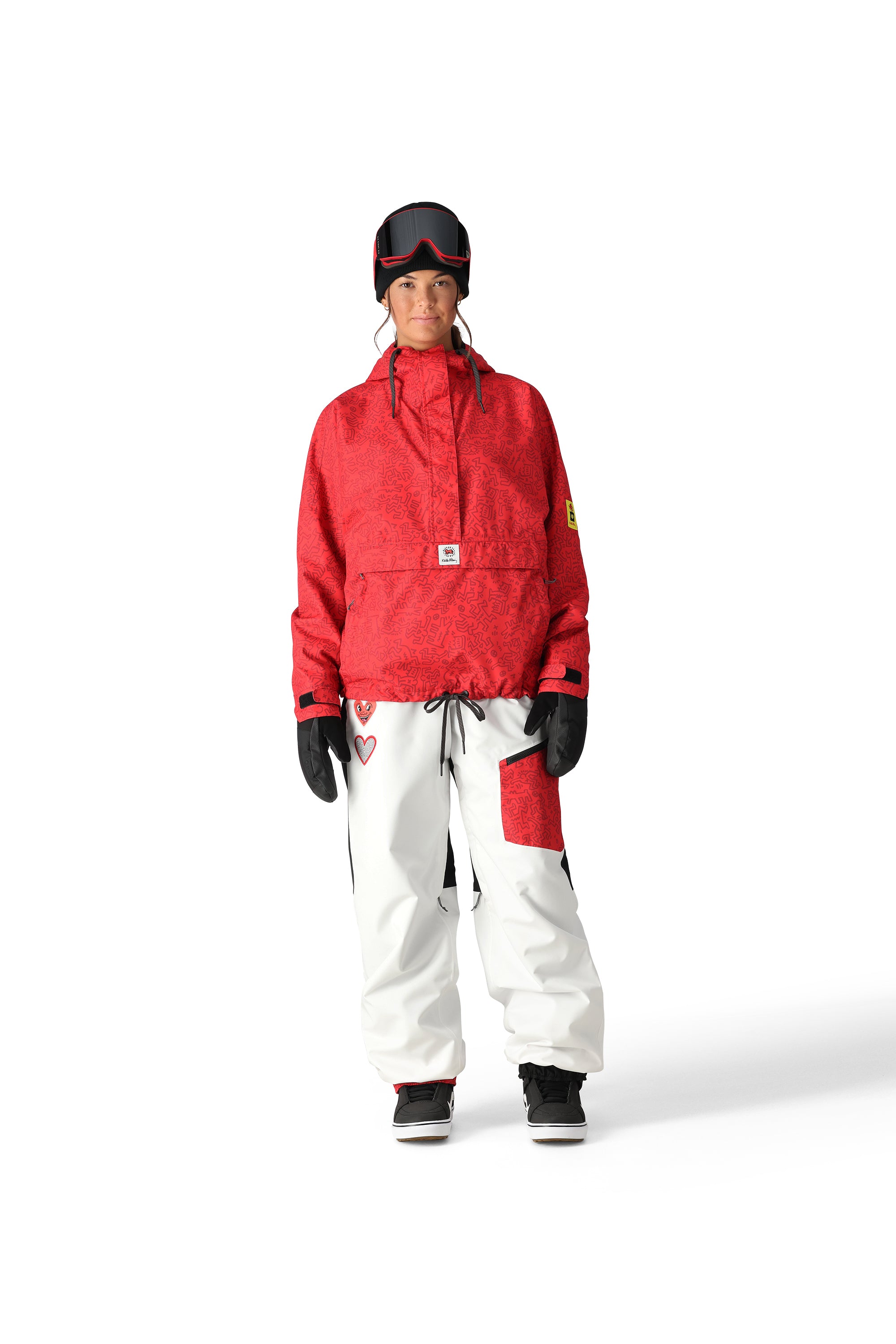 The 686 women's Outline Shell Anorak has a red and black patterned shell with a high collar and zippered pockets on either side.