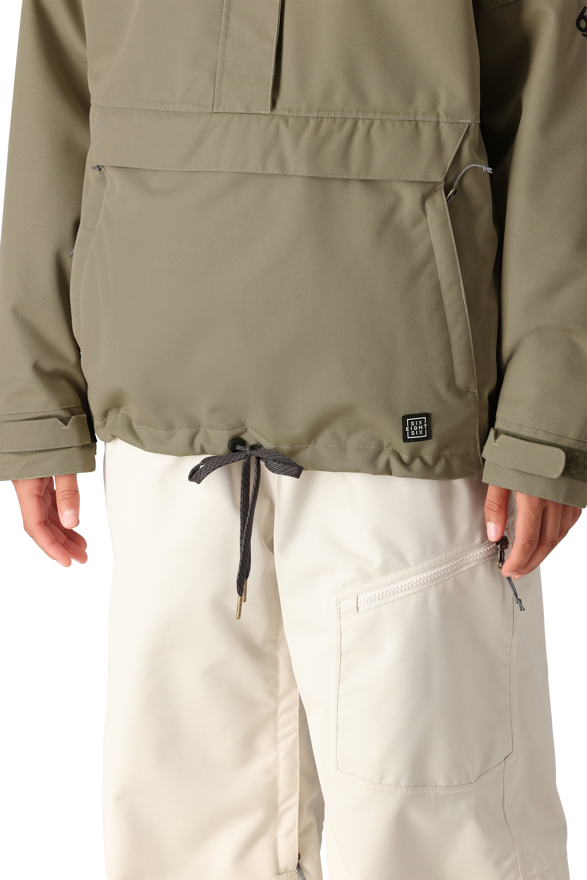 The 686 Women's Outline Shell Anorak 2025 jacket is olive green with an insulated hood and drawstring waist.