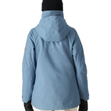 The 686 Women's SMARTY 3-in-1 Spellbound Jacket in light blue has a hood and appears to be fully zipped up.