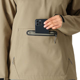 The 686 Women's Waterproof Hoody 2025 is shown in the image from the front view, with a tan color and a zippered pocket on the chest.