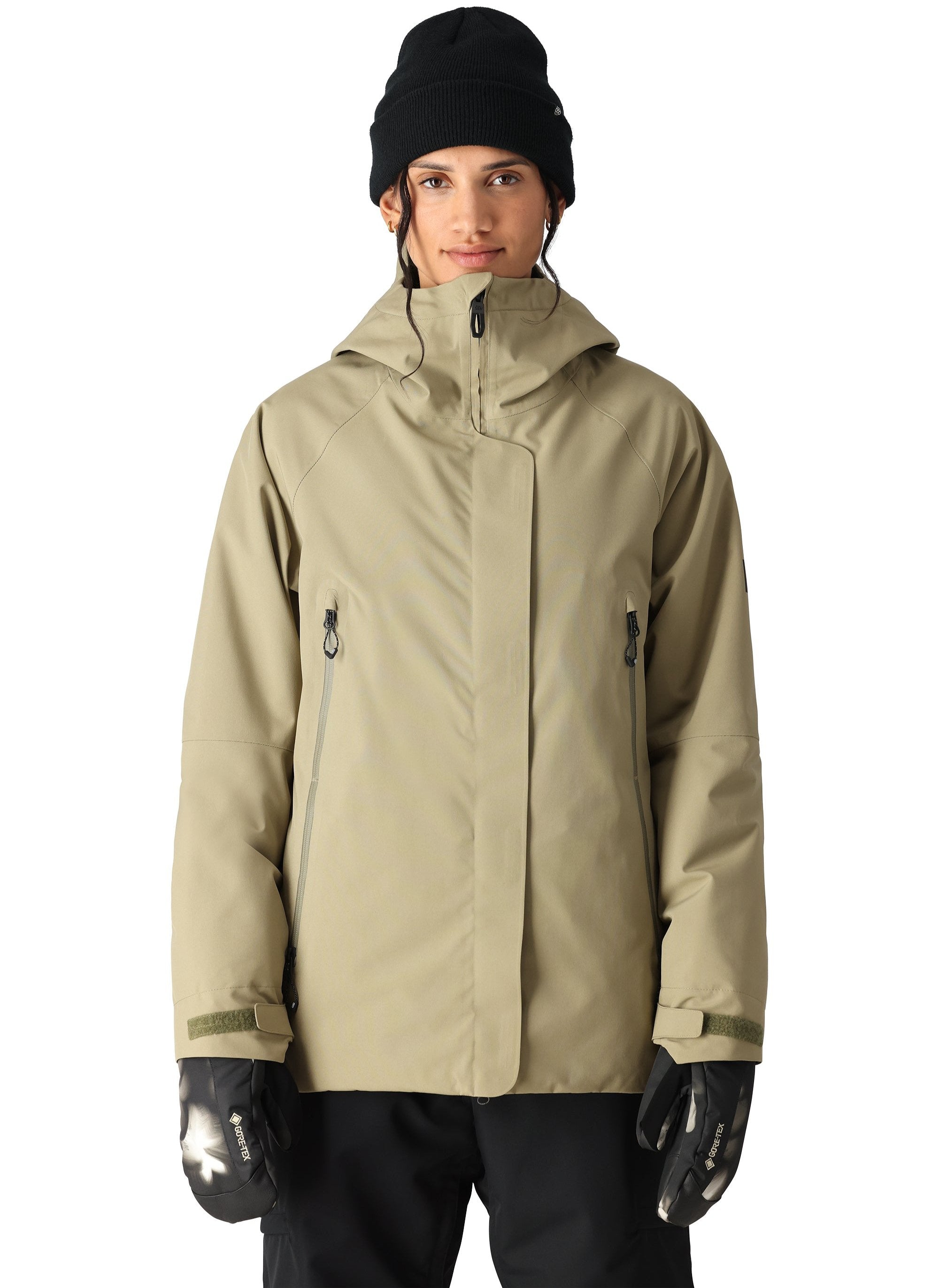 The 686 Whisper Insulated Jacket in tan has a high collar and zippered pockets.