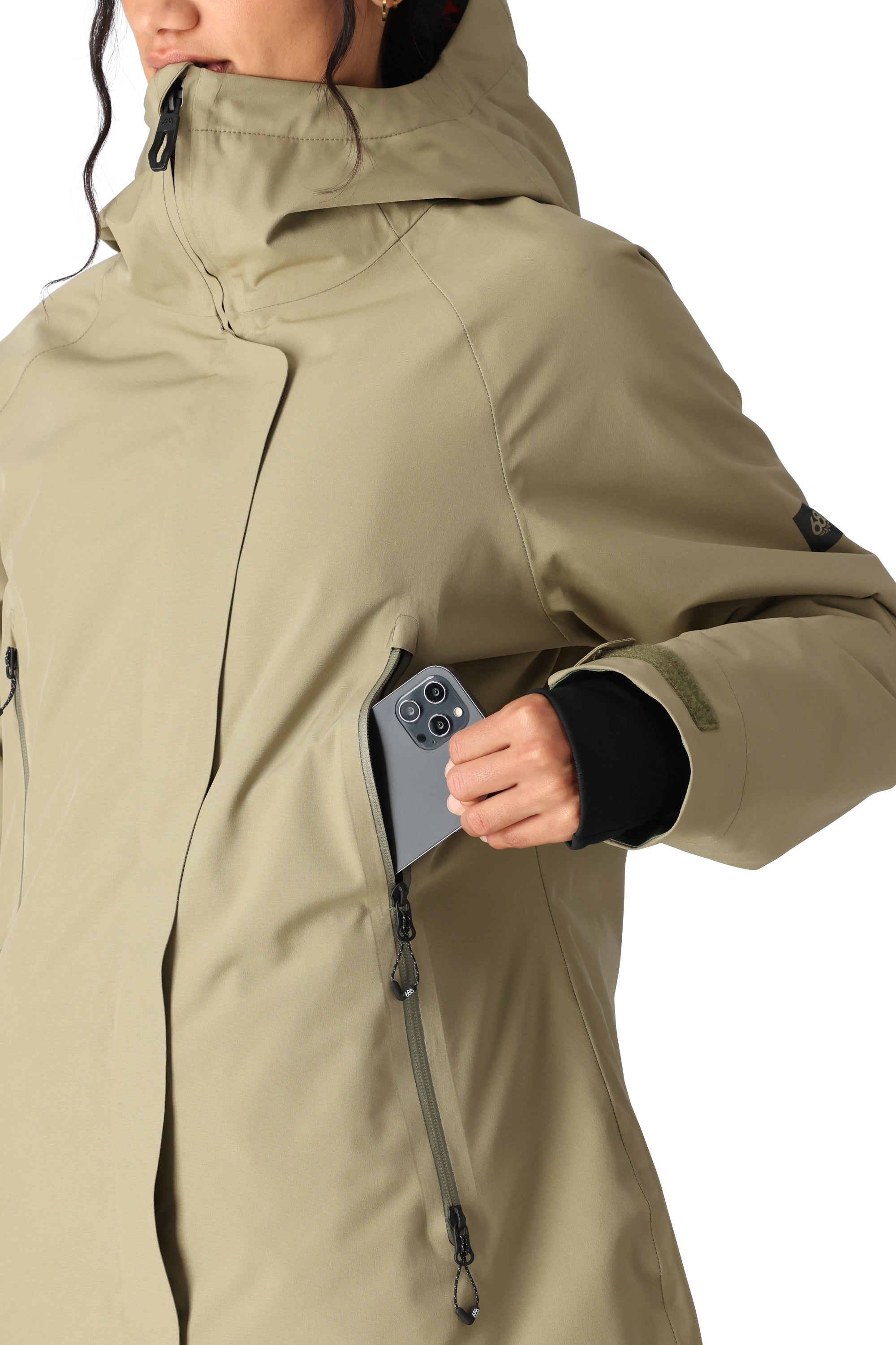 The 686 Whisper Insulated Jacket for women is a light tan color with an insulated hood and a front zipper.