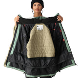The 686 Women's Whisper Insulated Jacket 2025 is primarily black with sage green accents and an insulated hood.